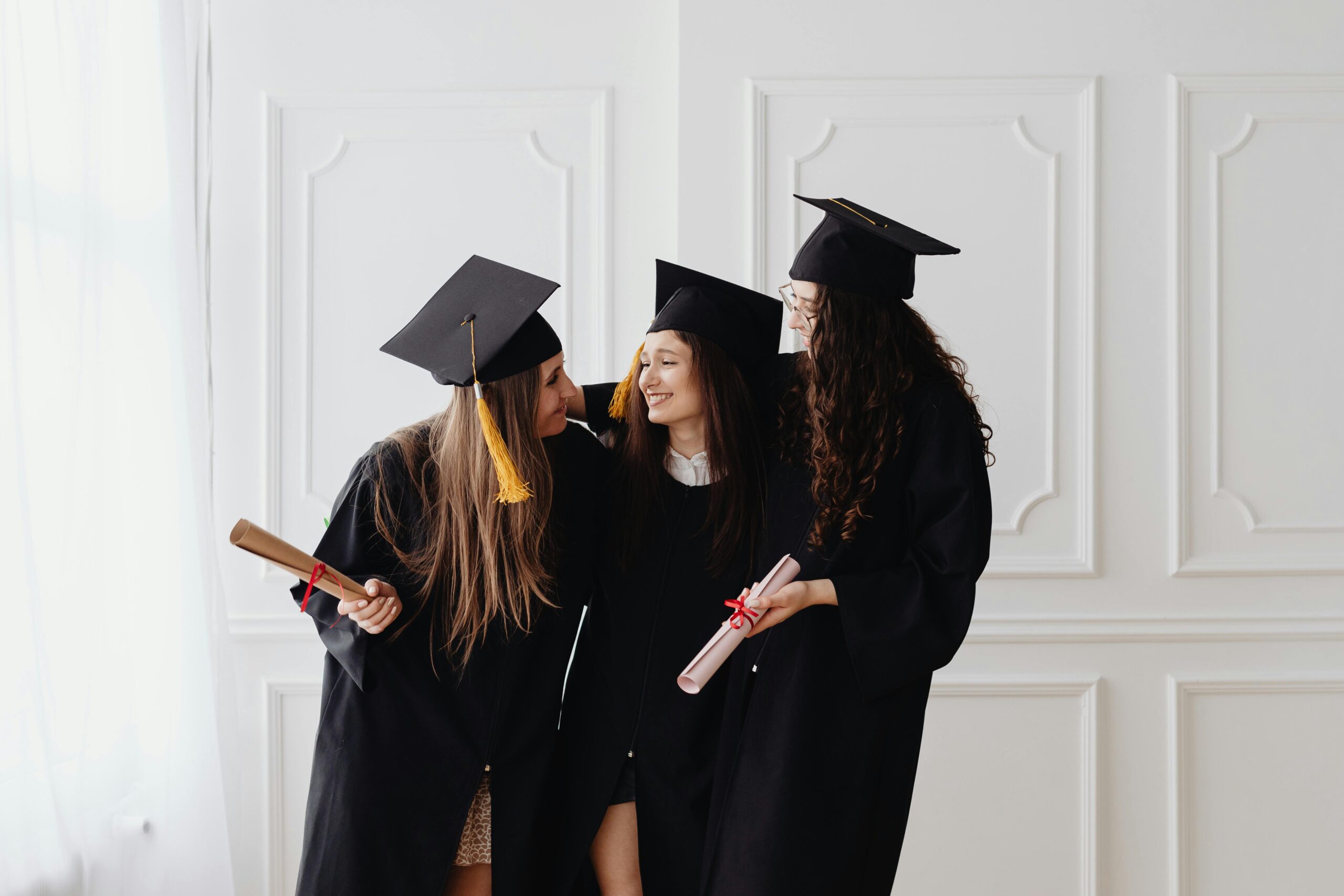 Tres jovens mulheres felizes em se graduar